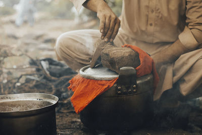 Close-up of people working on barbecue grill