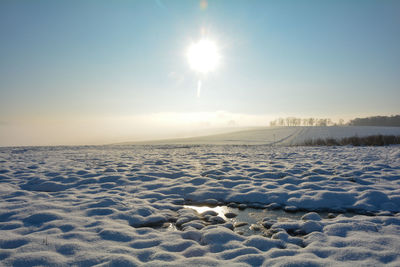 Scenic view of snow covered land against sky