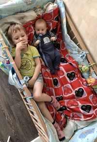 High angle view of siblings sitting on floor