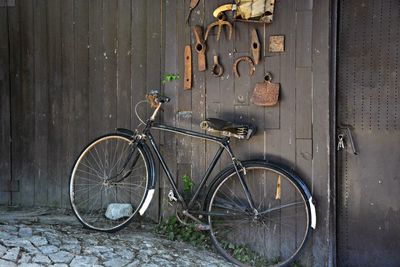 Bicycle leaning on wooden wall