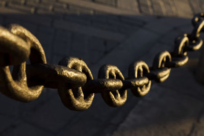 Close-up of rusty chain against wall