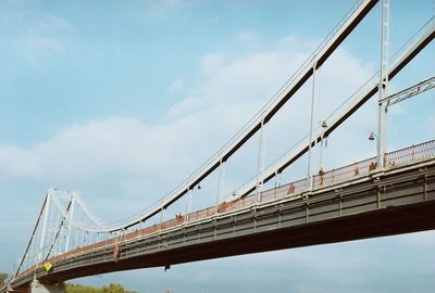 Low angle view of suspension bridge against sky