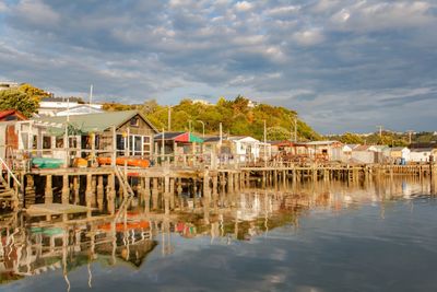 Houses by lake against sky in city