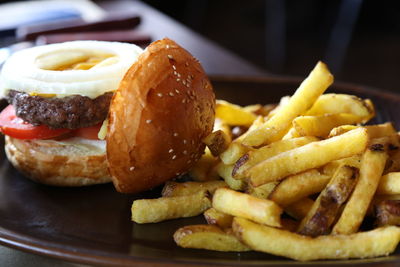 Close-up of hamburger and french fries in plate on table