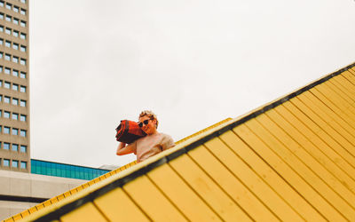 Low angle view of young woman against sky