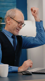 Midsection of man using mobile phone on table