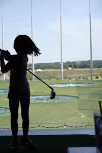 Full length of woman standing on golf course