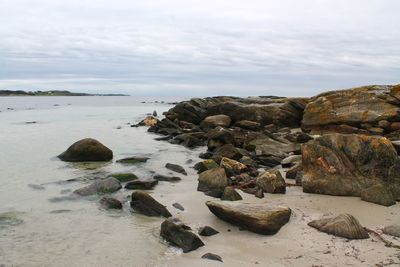 Rocks on beach against sky