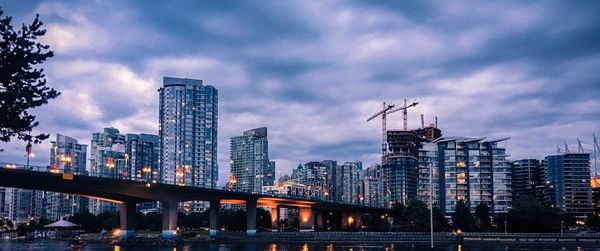 Modern buildings against sky in city at dusk