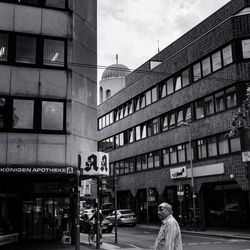 Man on street in city against sky