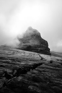 Rock formations on shore against sky