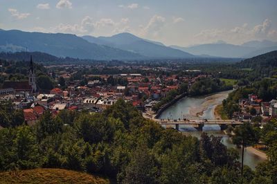 Aerial view of river and town against cloudy sky