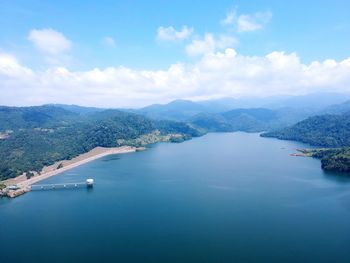 Scenic view of sea and mountains against sky