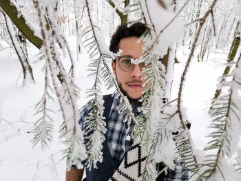 Portrait of man with snow covered tree