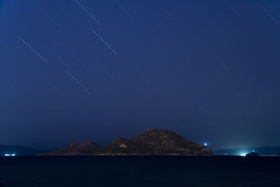 Scenic view of sea against star field at night