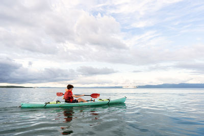 Teenager paddling kayak in costa rica