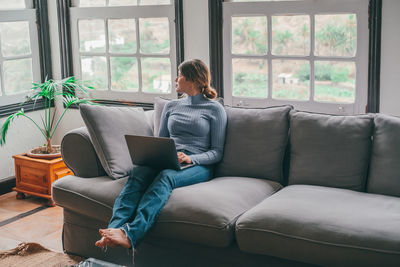 Portrait of woman sitting on sofa at home