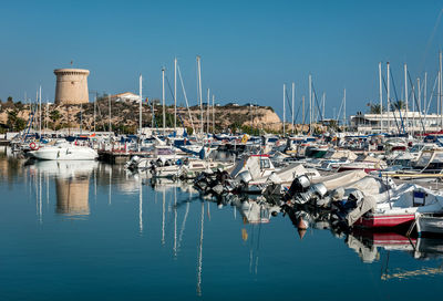 Boats moored at costa blanca harbor against clear sky