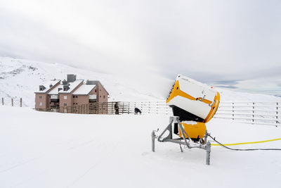 Yellow flag on snow covered field against sky