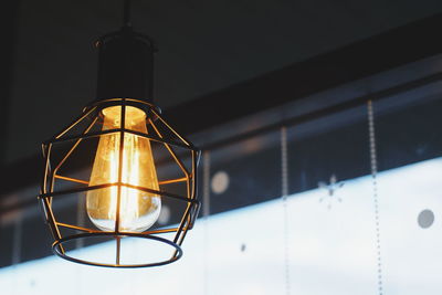 Close-up of illuminated pendant light hanging from ceiling