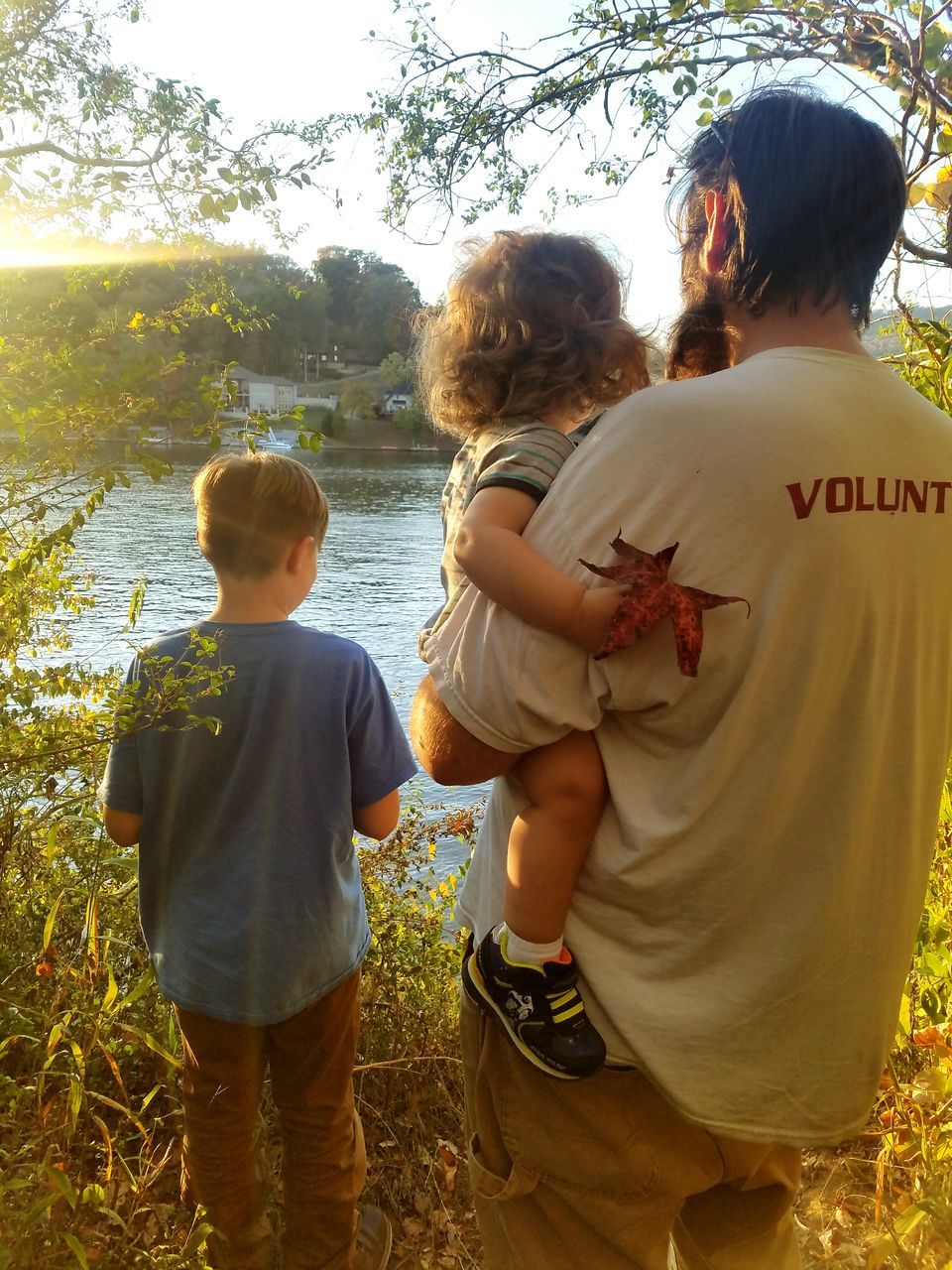 family, rear view, togetherness, males, love, child, son, father, childhood, care, bonding, sunlight, happiness, people, two people, baby, outdoors, adult, day, tree, unity