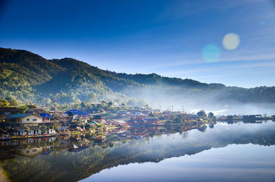 Scenic view of buildings and mountains against sky