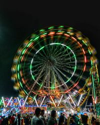 Low angle view of illuminated ferris wheel against sky at night