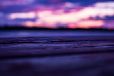 Surface level of land against sky during sunset
