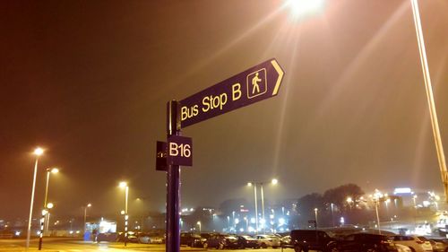 Low angle view of road sign at night