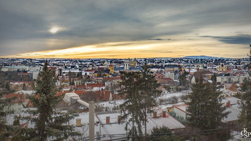 High angle view of buildings in city against cloudy sky during sunset