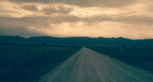 Country road against dramatic sky at sunset