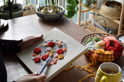 Woman cross-stitching at home in morning