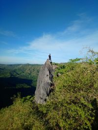 Man standing on mountain top against sky