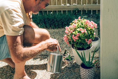 Midsection of man standing in flower pot