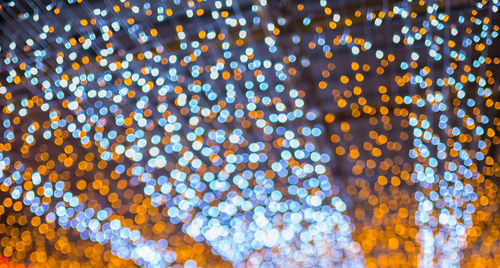 Low angle view of illuminated lights against sky at night