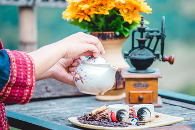 Midsection of woman holding coffee on table