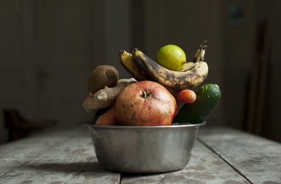 Fruits and vegetables in container on table