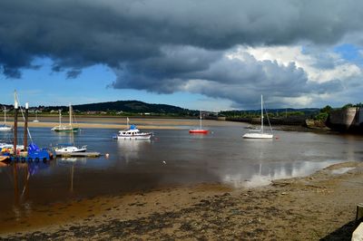 Boats moored on sea against sky