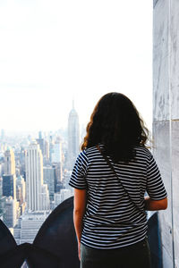 Rear view of man standing against buildings in city