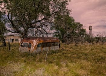 Abandoned train on landscape against sky