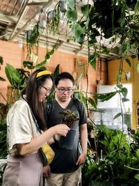 Portrait of smiling senior woman sitting by plants