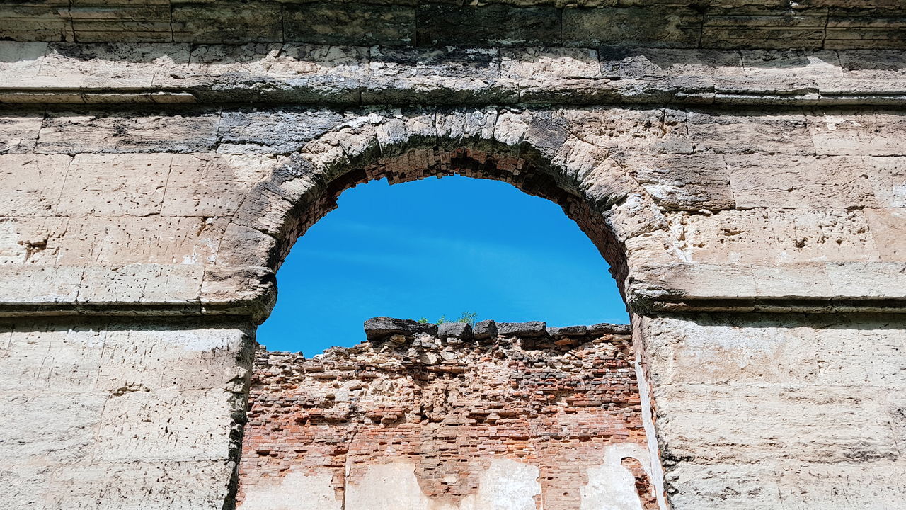 DAMAGED WALL AGAINST SKY SEEN THROUGH HOLE IN WALLS OF BUILDING