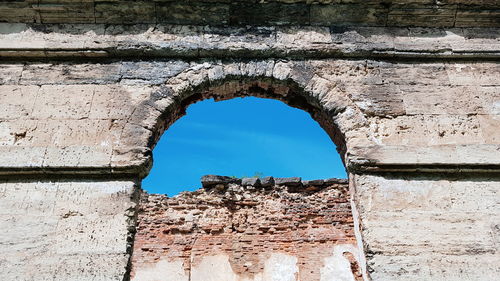 Damaged wall against sky seen through hole