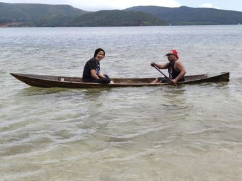 Men sitting on boat in lake