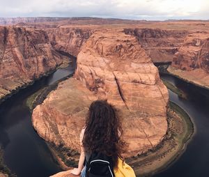 Rear view of woman sitting troughout horseshoe bend