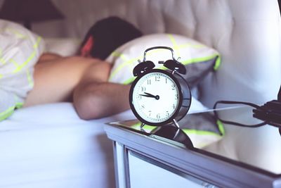 Low section of woman sleeping on bed at home