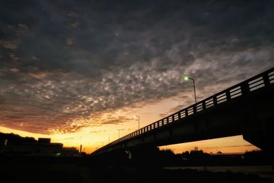 Silhouette bridge against sky at night