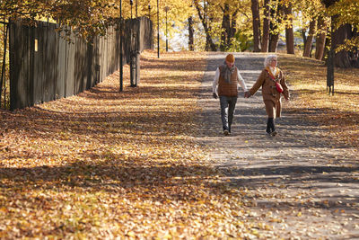 Rear view of people walking on road