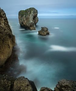 Rocks in sea against sky