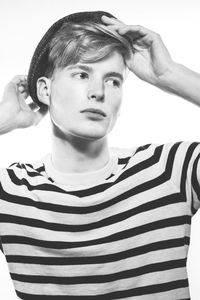 Portrait of young man standing against white background